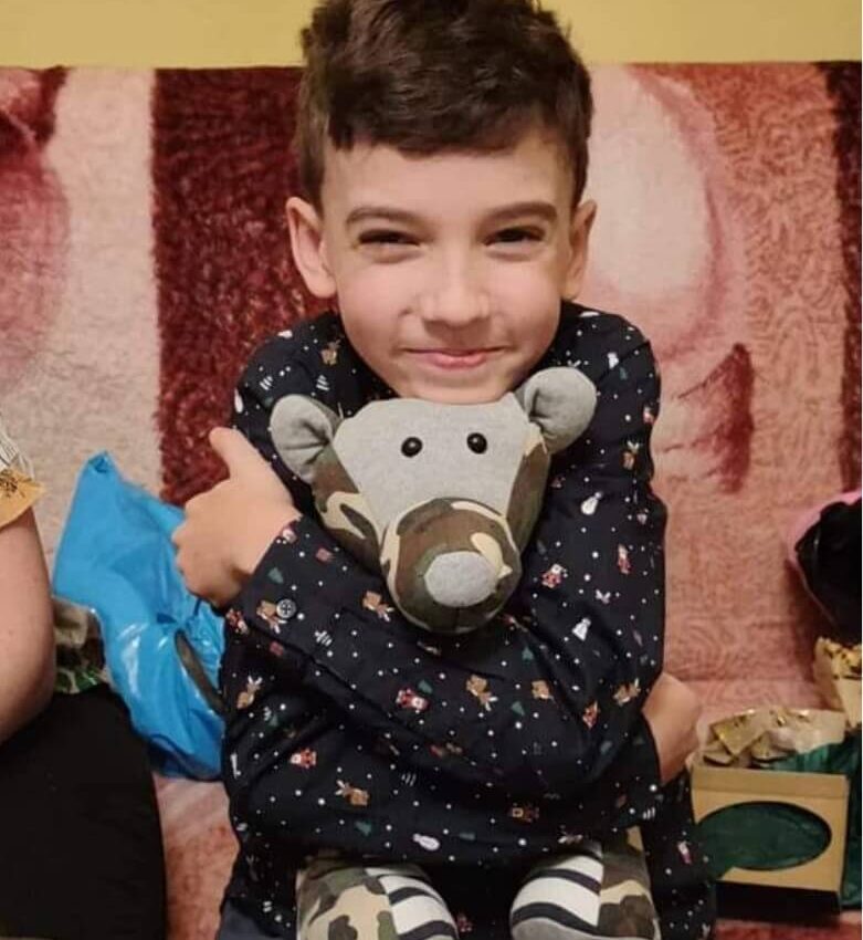 usmiechniety chlopczyk z misiem w objeciu pluszak maskotka paiatka prezent