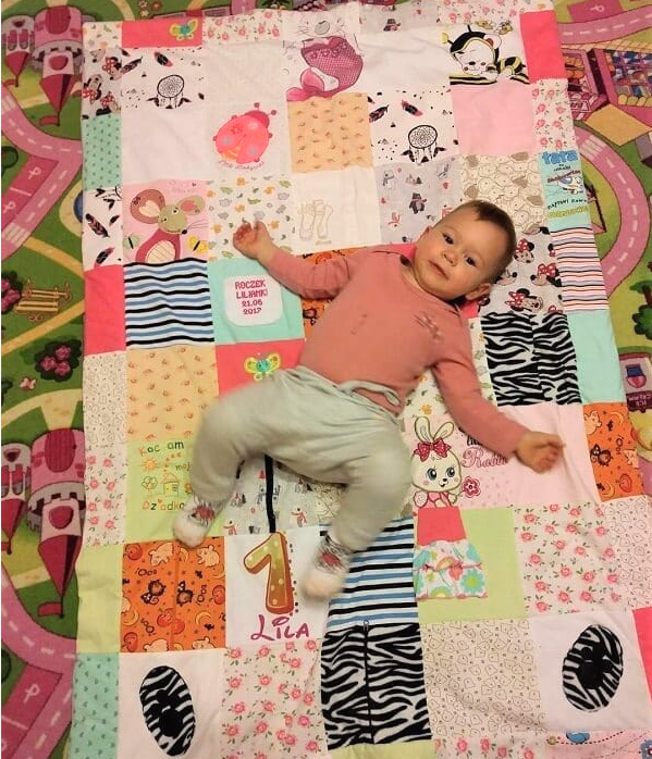 dziecko leży na kocyku patchwork